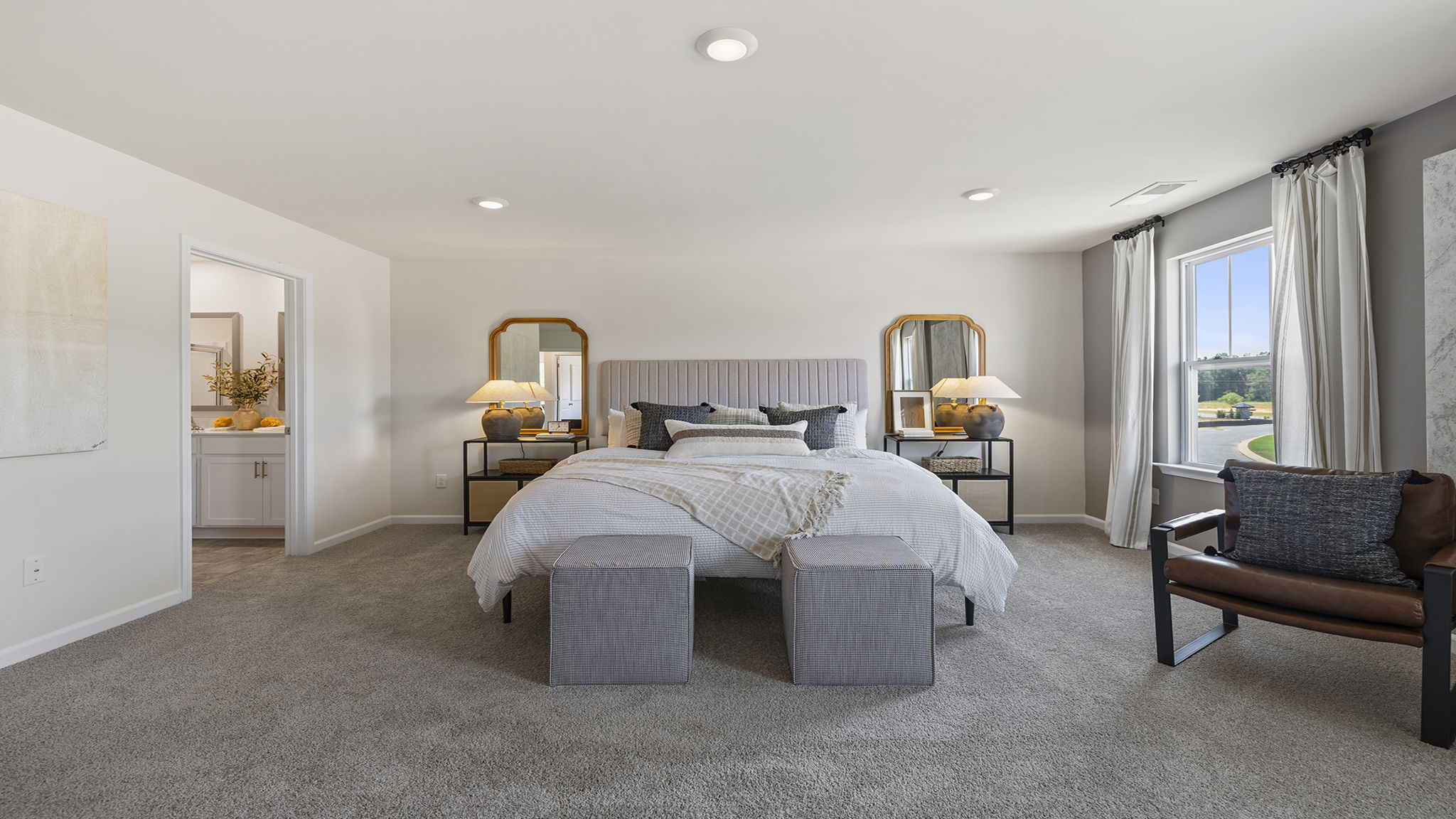 Primary bedroom with carpet and window.