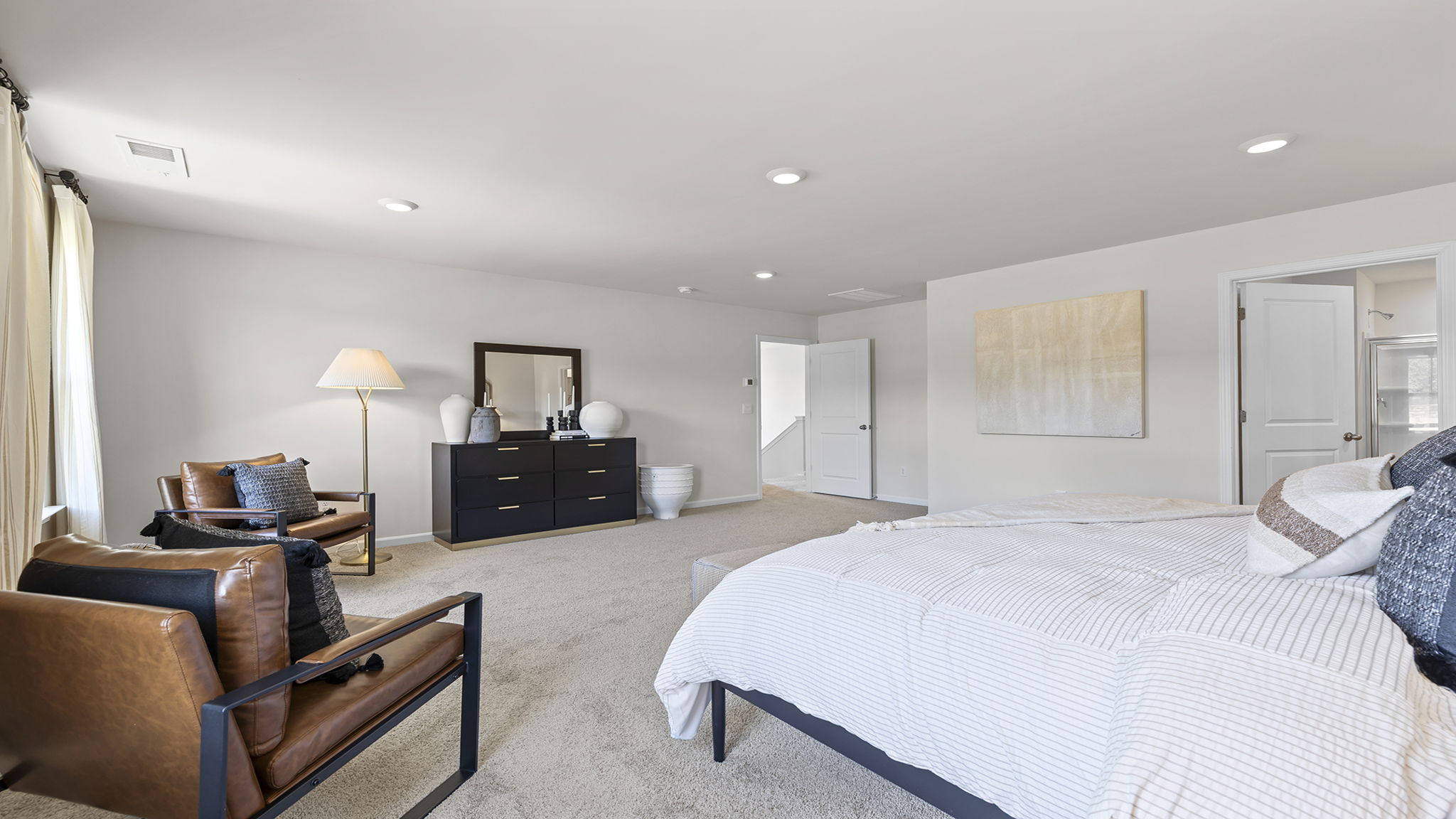 Primary bedroom with carpet and window.