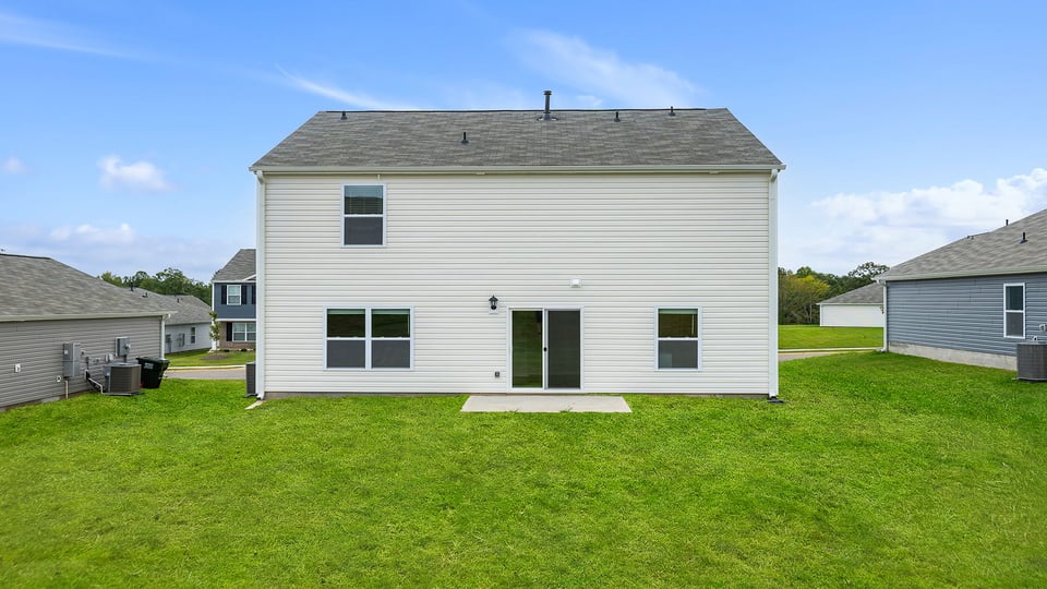 Back exterior with patio and large backyard.