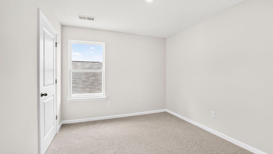 Bedroom with carpet and window.