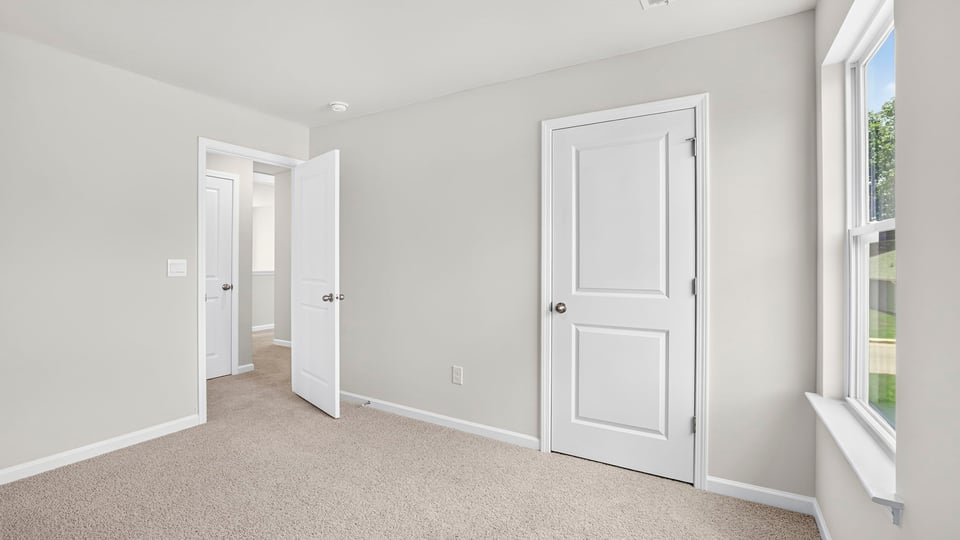 Bedroom with carpet and window.