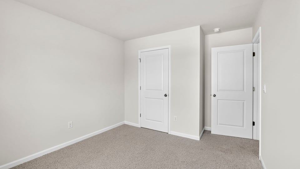 Bedroom with carpet and window.