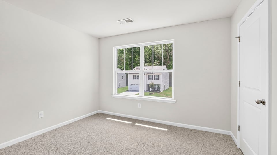 Bedroom with carpet and window.