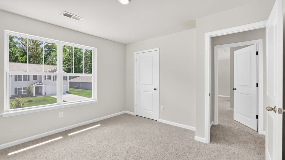 Bedroom with carpet and window.
