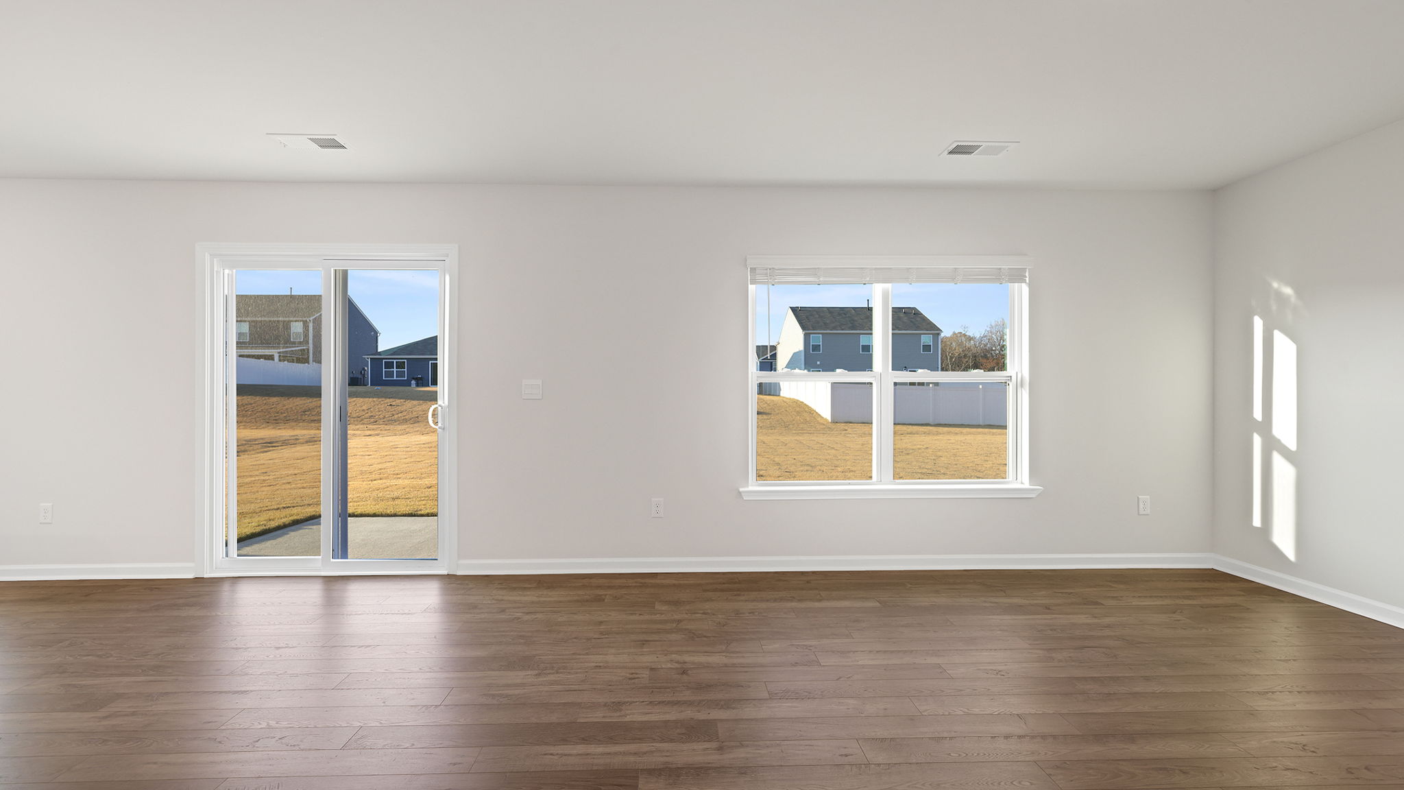 View of large windows and patio door to the backyard, providing lots of natural light .
