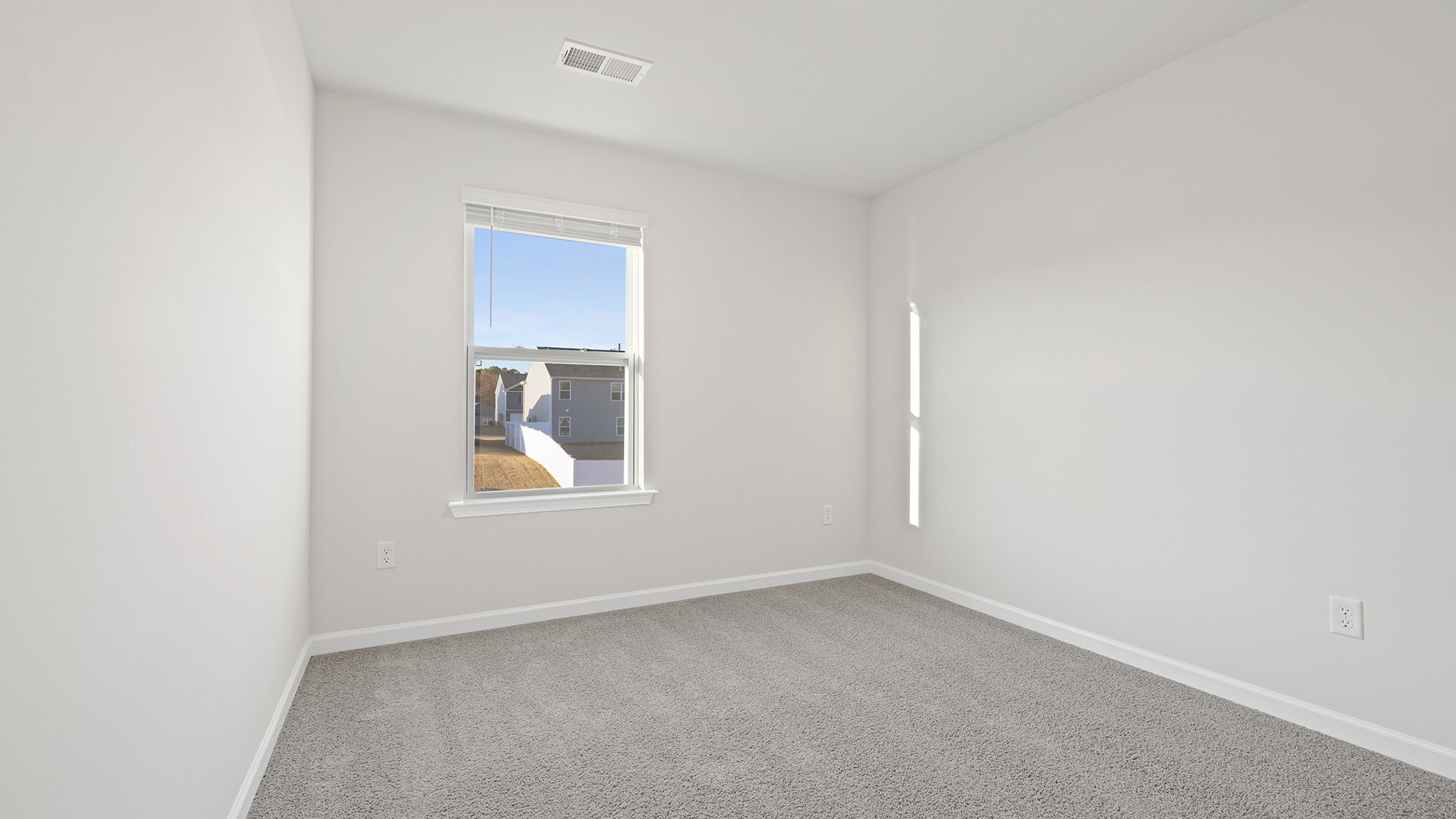 Bedroom with large window and carpet.