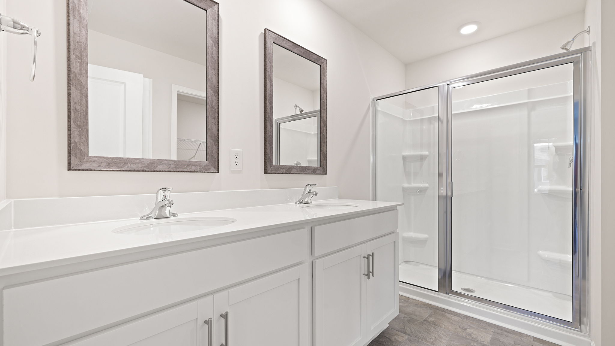Primary bath with walk in shower and dual sink vanity .