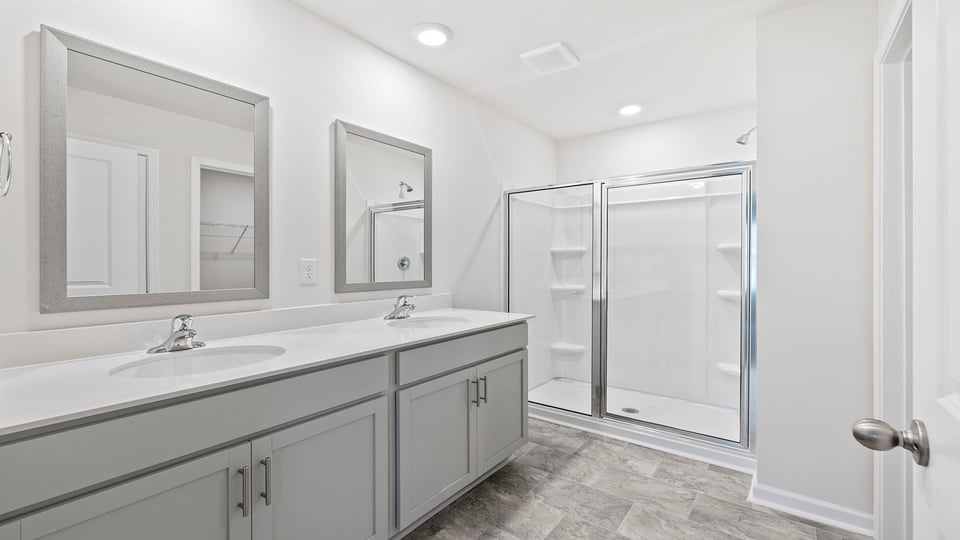 Primary bathroom with dual sink vanity and walk-in shower.