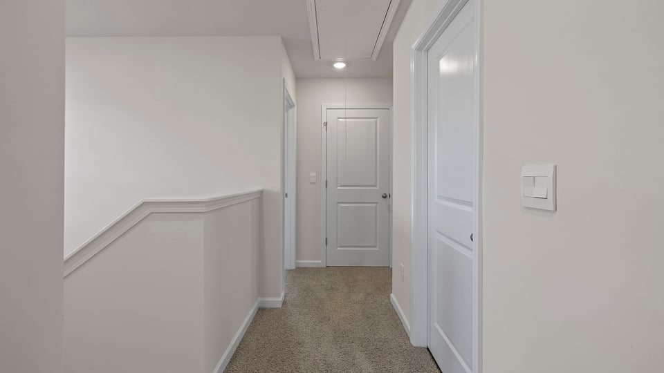 Hallway to bedrooms with carpet.