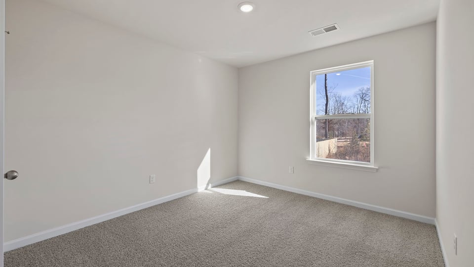 Bedroom with carpet and windows.