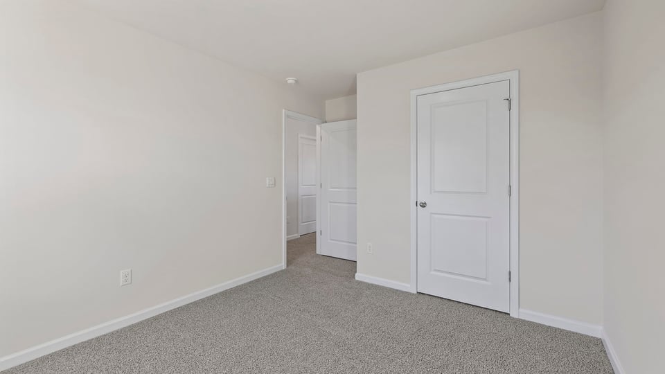 Bedroom with carpet and windows.