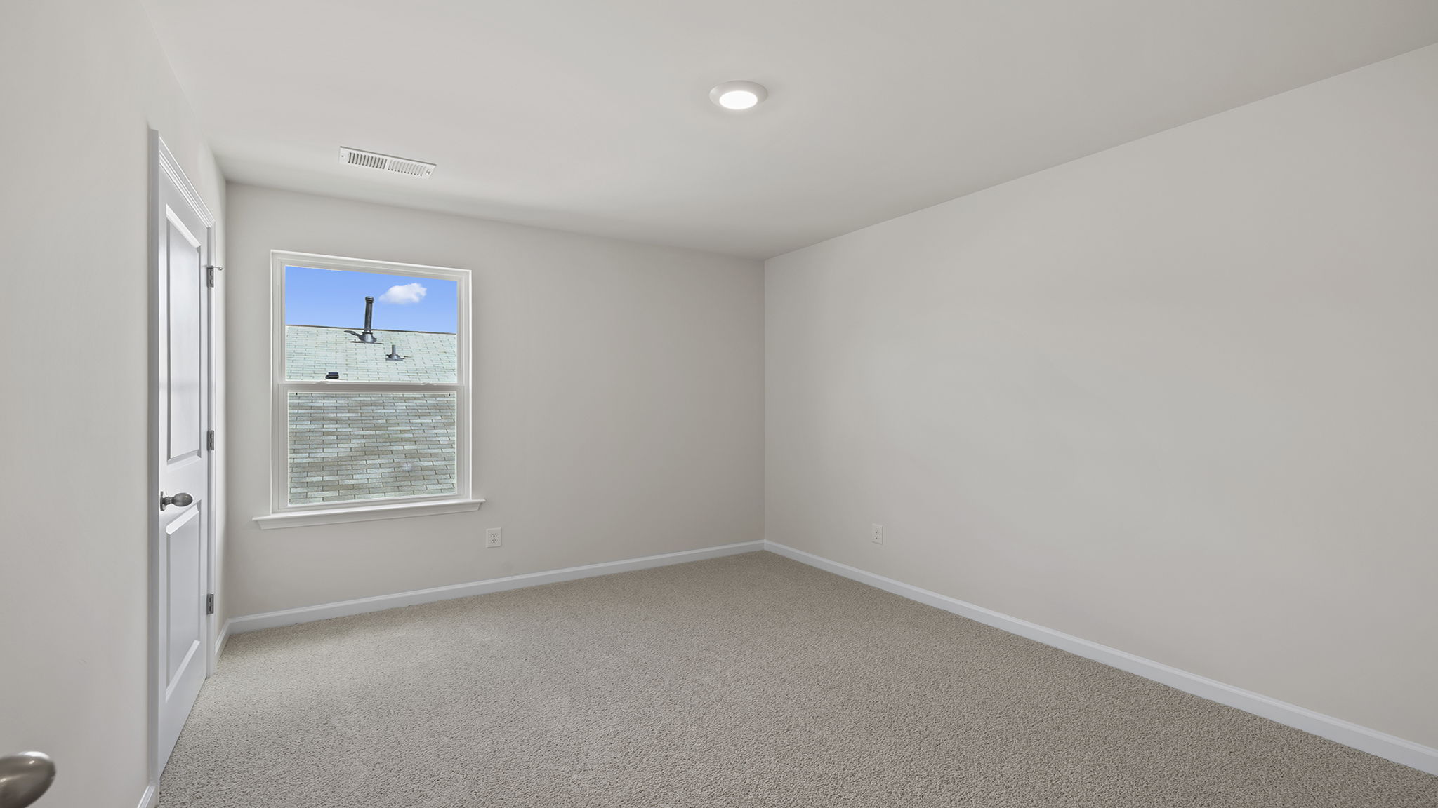 Bedroom with window and carpet.