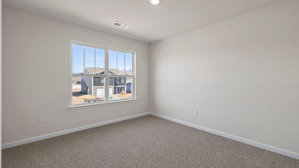 Bedroom with carpet and windows.