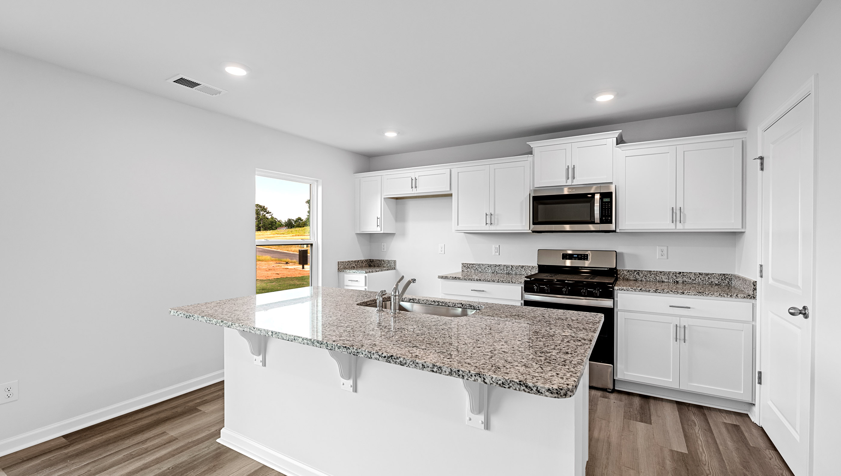 Kitchen and island have quartz countertops.