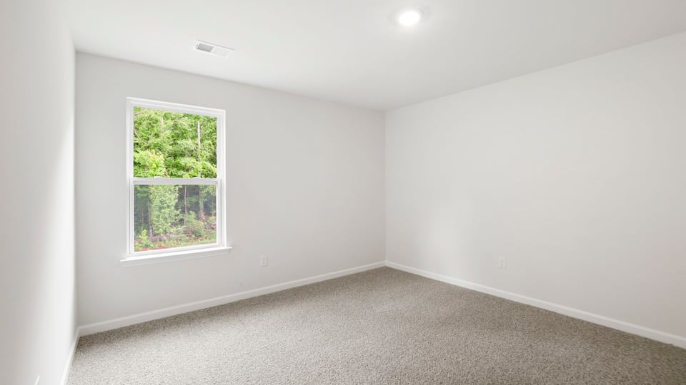 Bedroom with carpet and window.