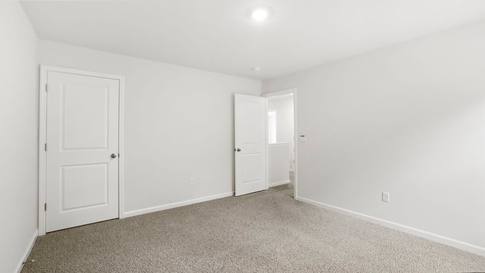 Bedroom with carpet and window.
