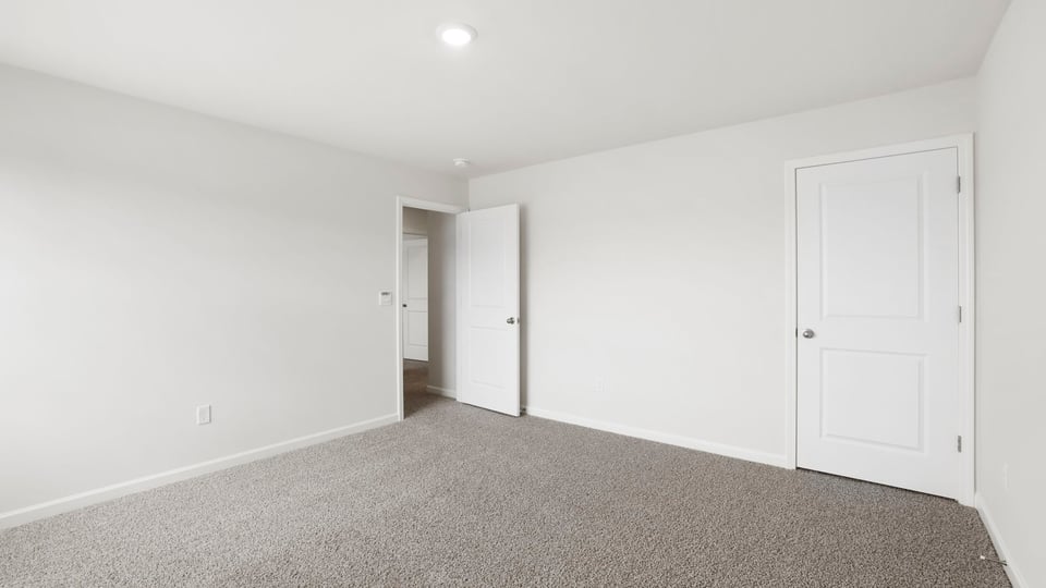 Bedroom with carpet and window.