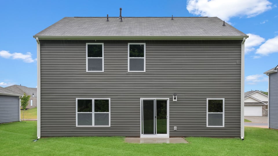 Back exterior of home with large backyard.
