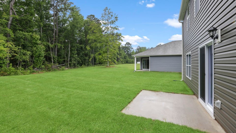 Back exterior of home with small patio.
