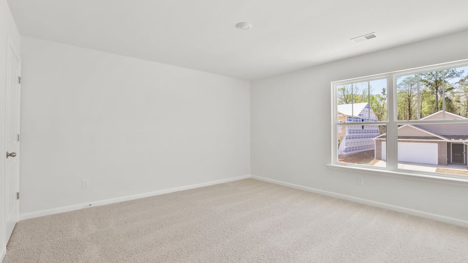 Bedroom with carpet and windows.