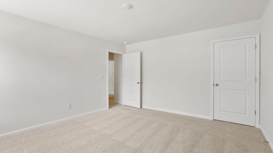 Bedroom with carpet and windows.