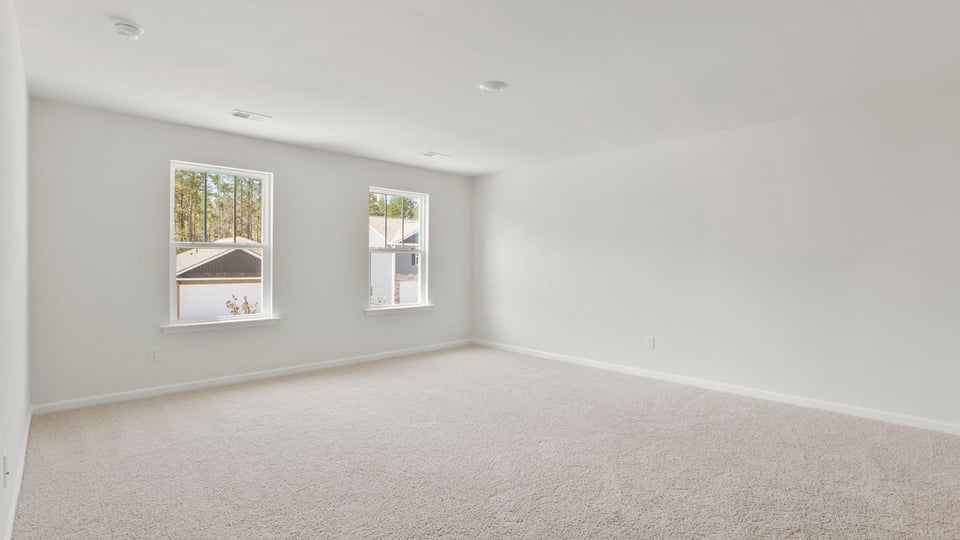Bedroom with carpet and windows.