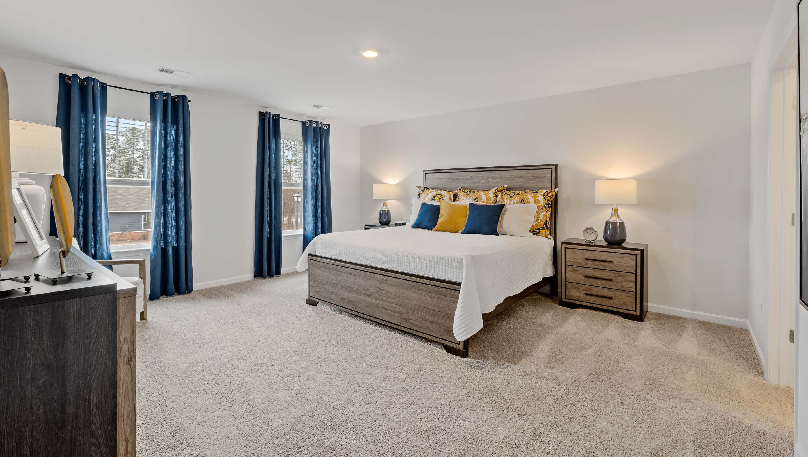 Primary bedroom with carpet and windows.