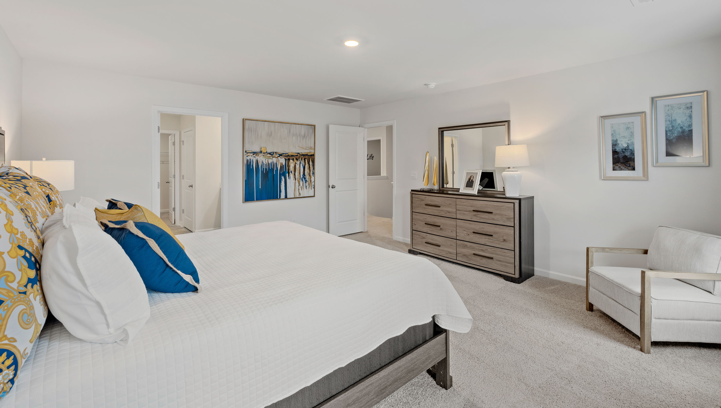 Primary bedroom with carpet and windows.