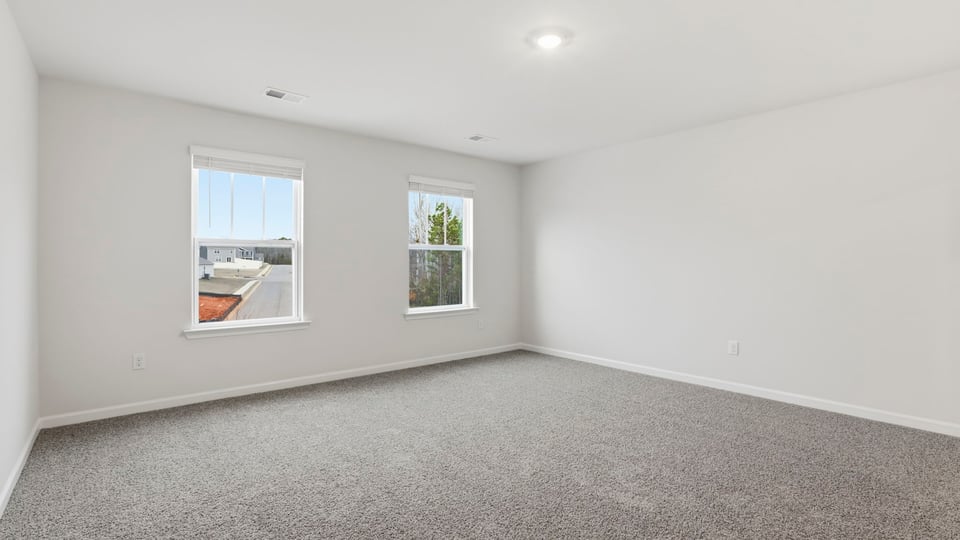 Primary bedroom with large windows.
