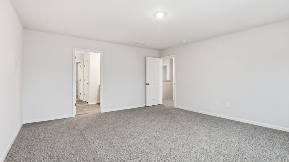 Primary bedroom with large windows.