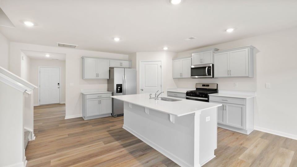 Kitchen and island with quartz countertops.