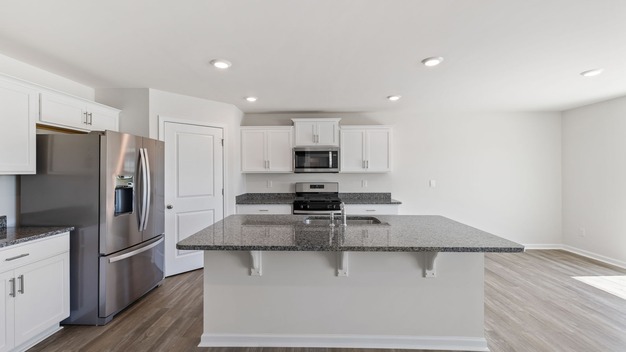 Kitchen with island featuring quartz countertops.