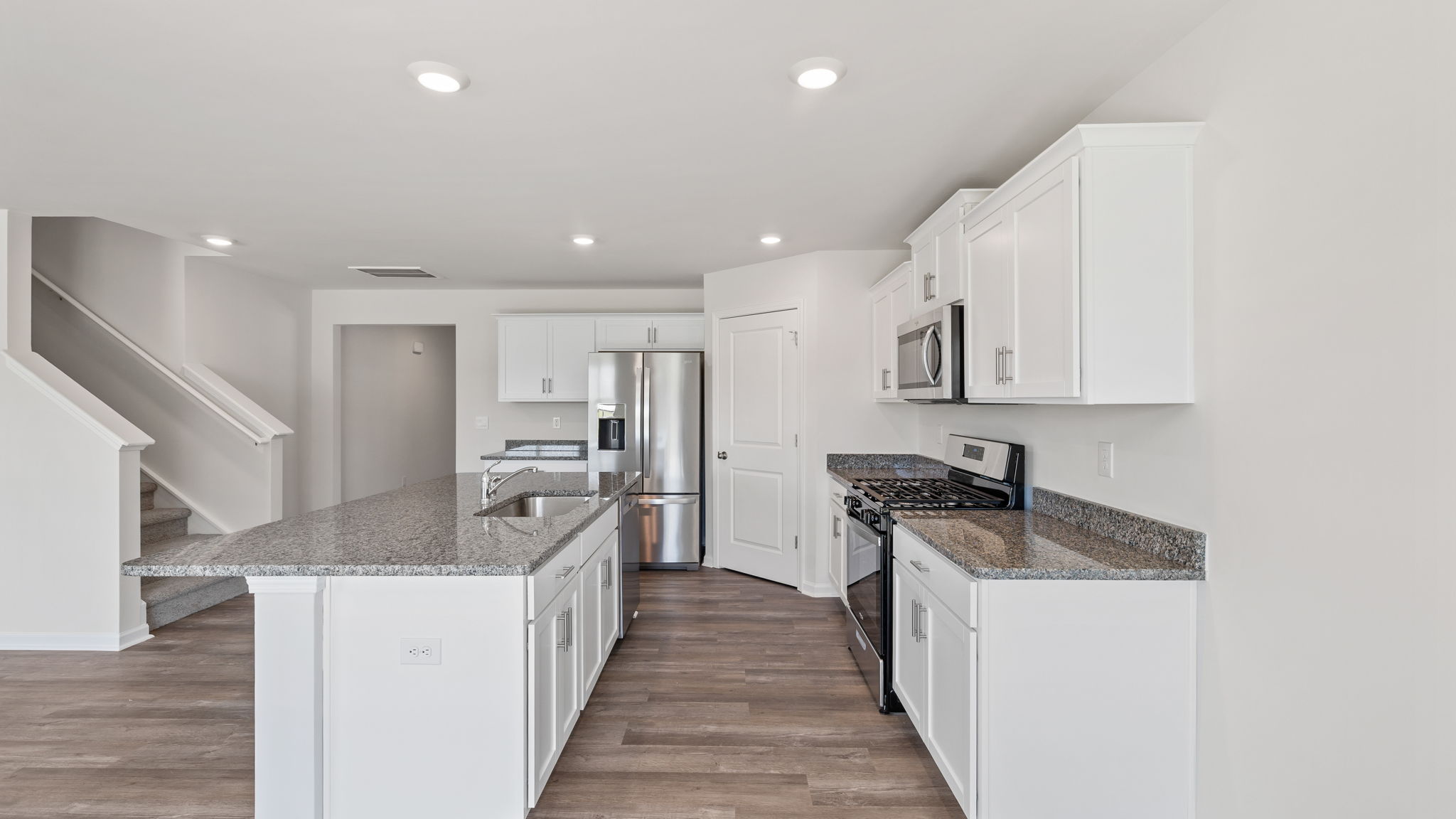 View of kitchen and stairwell.