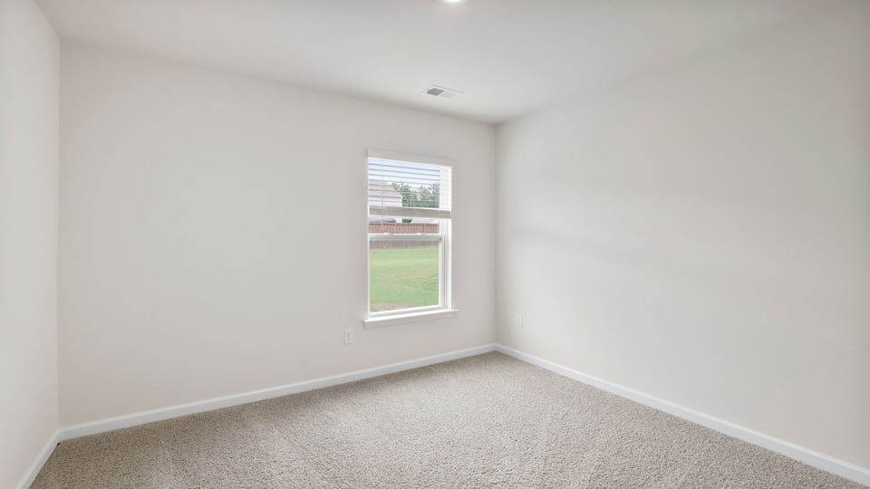 Bedroom with carpet and window.