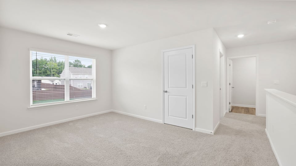Loft area with carpet and window.