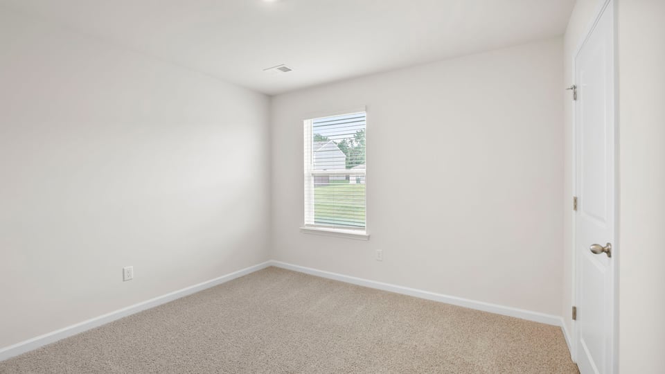Bedroom with carpet and window.