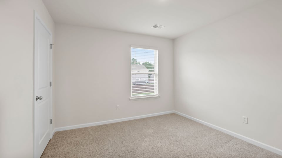 Bedroom with carpet and window.