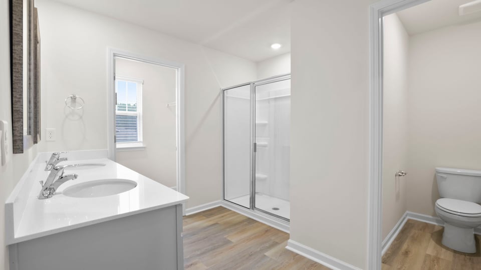 Bathroom with double vanity sink and walk in shower.