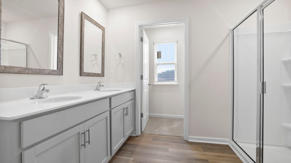 Bathroom with double vanity sink and walk in shower.