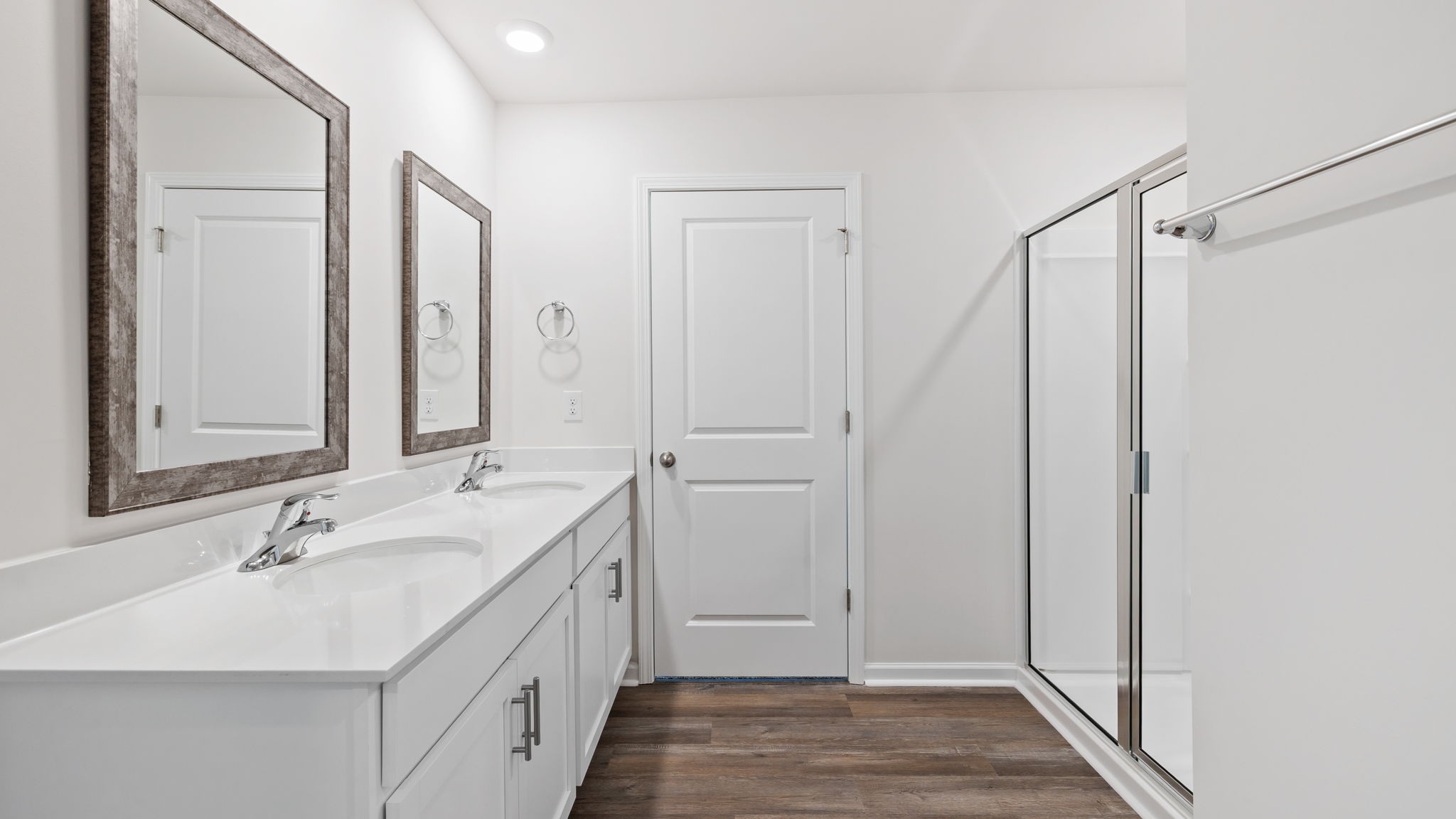 Primary bathroom with dual sink vanity and walk-in shower.