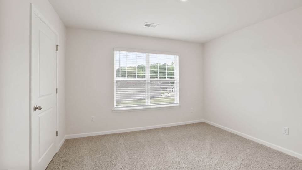 Bedroom with carpet and window.