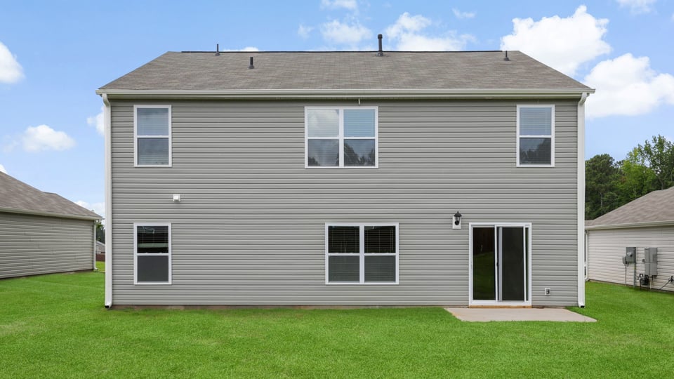 Back exterior of home with large backyard.
