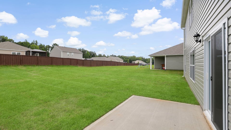 Back exterior of home with small patio.