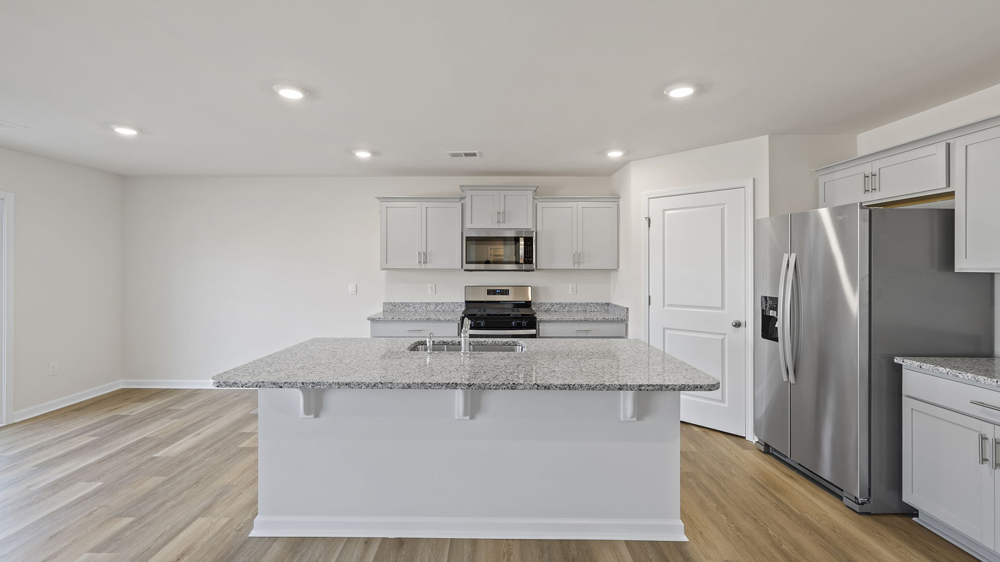 Kitchen and island have quartz countertops.