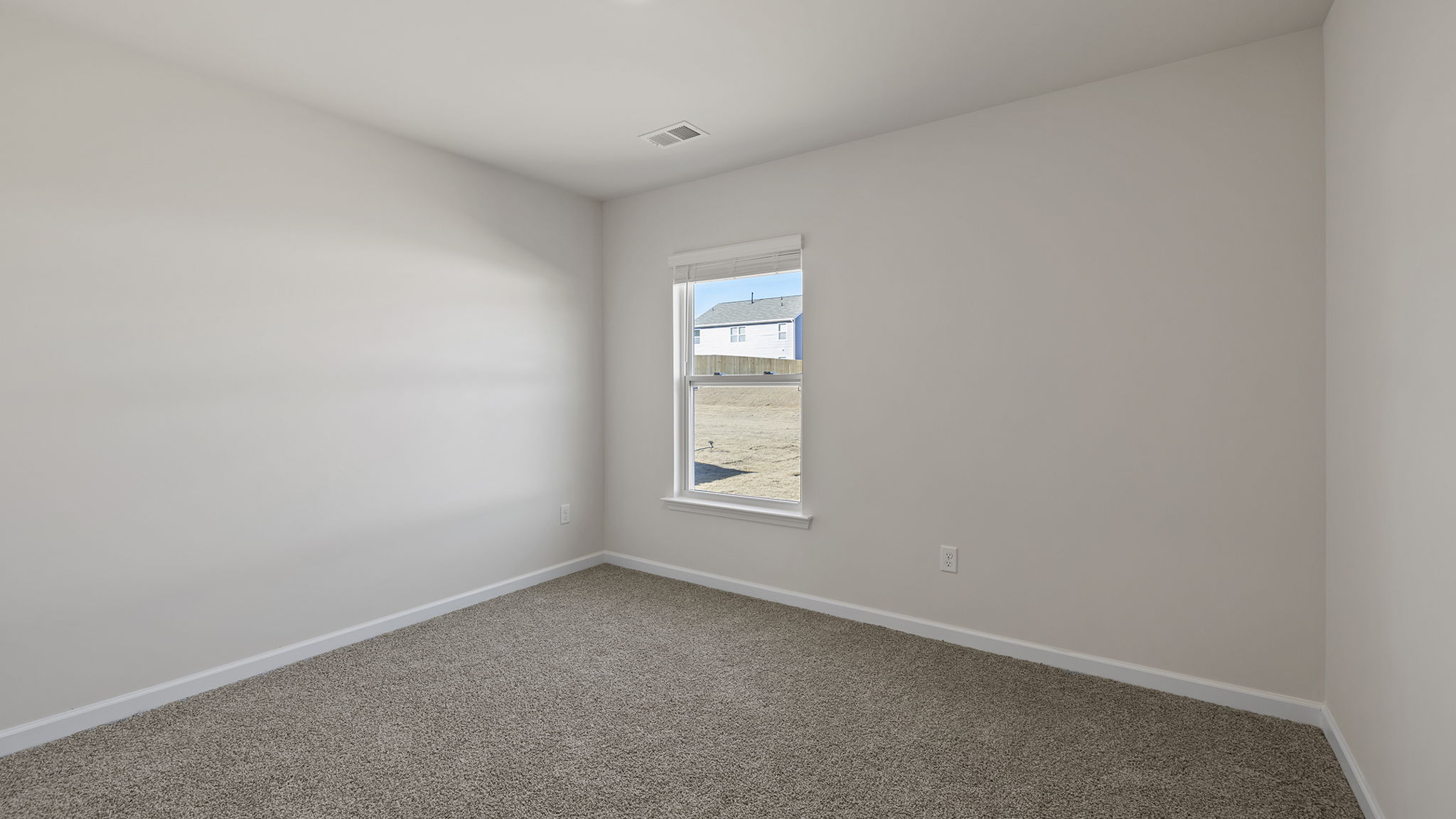 Bedroom on the main level with window and carpet.