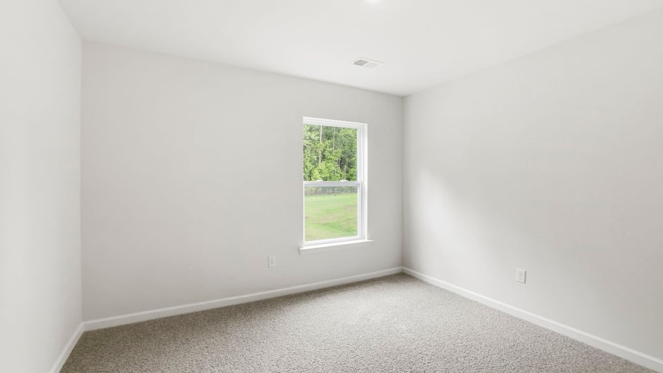 Bedroom with carpet and window.