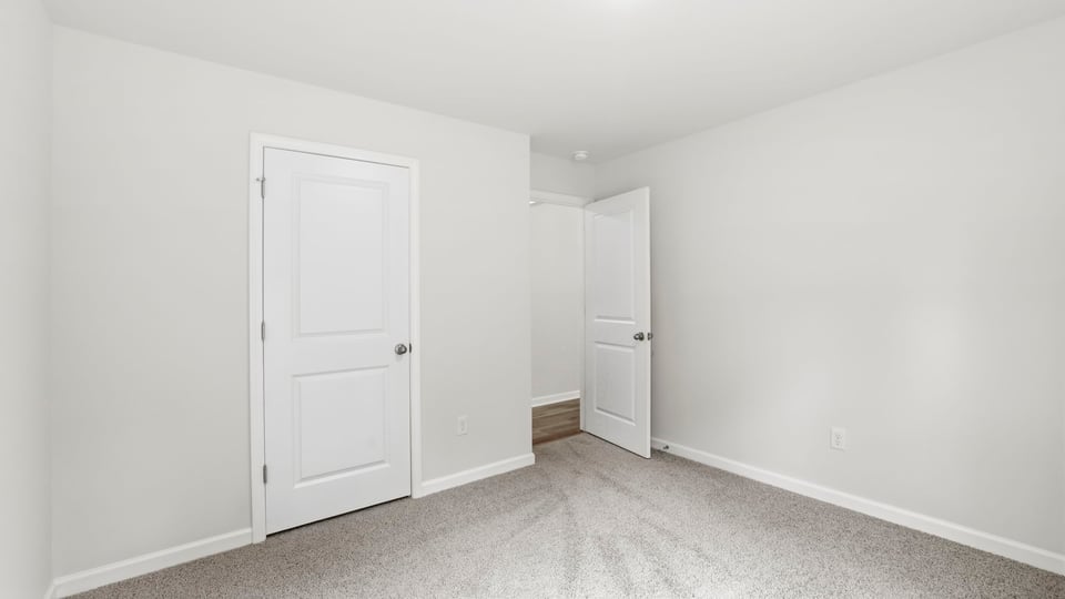 Bedroom with carpet and window.