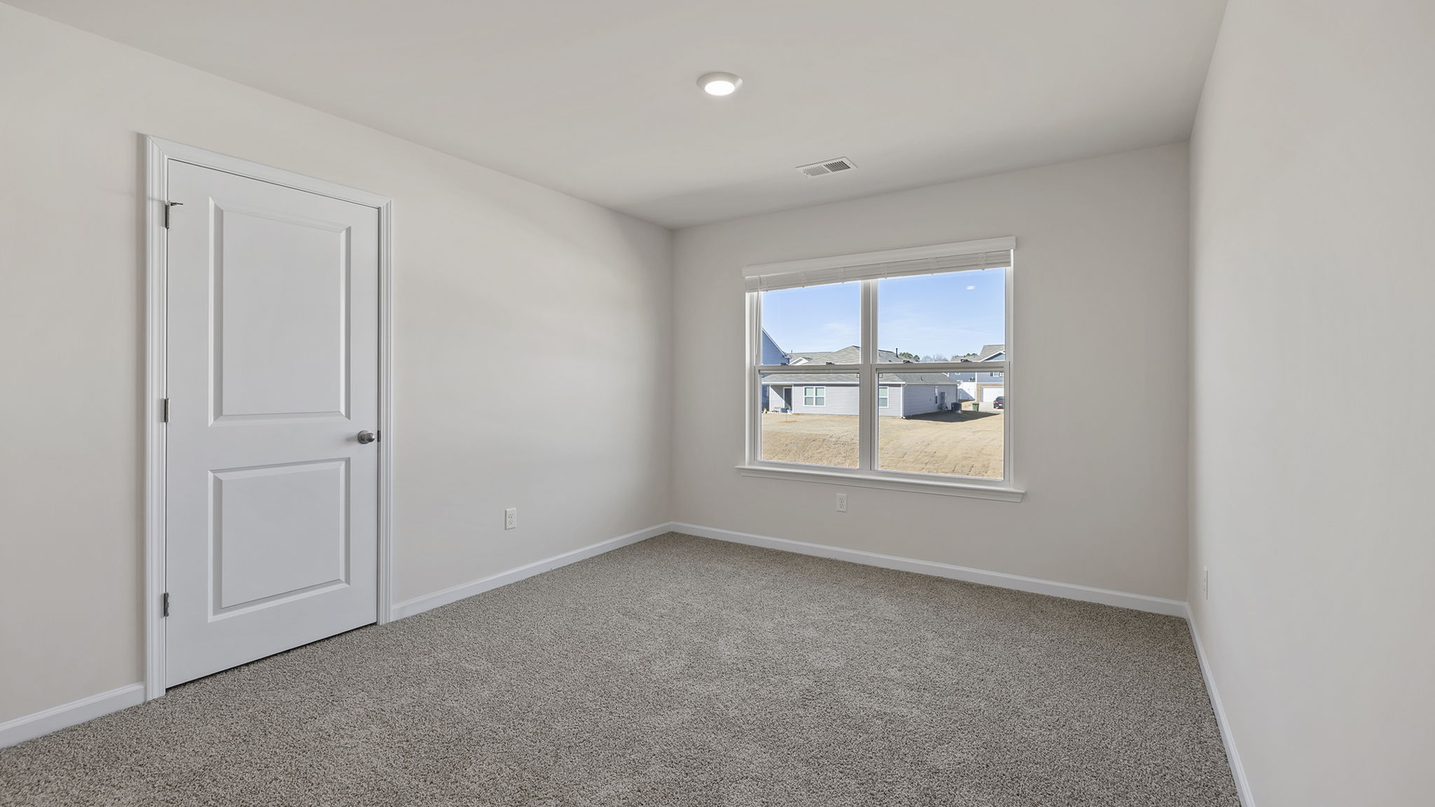 Loft area with large window and carpet.