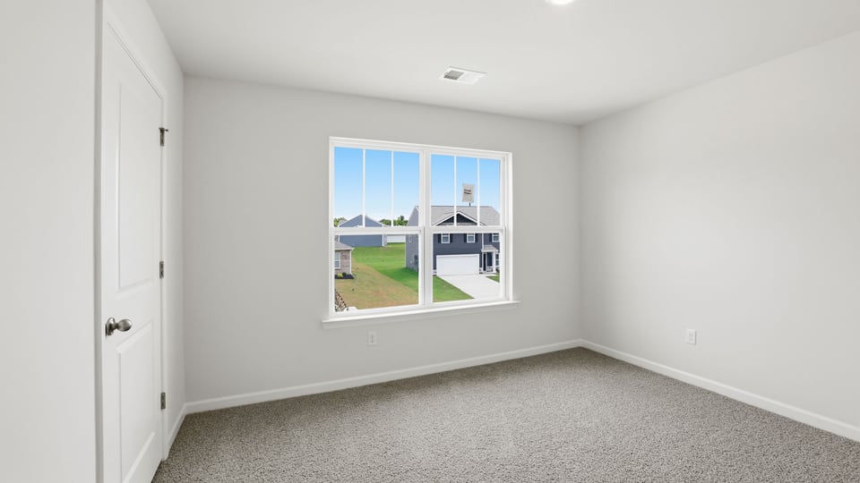 Bedroom with carpet and window.