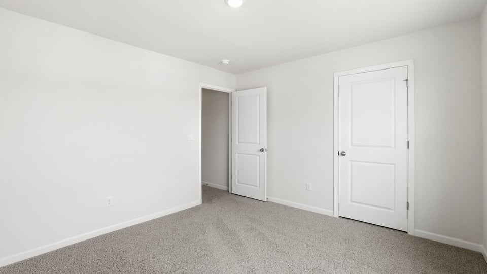 Bedroom with carpet and window.